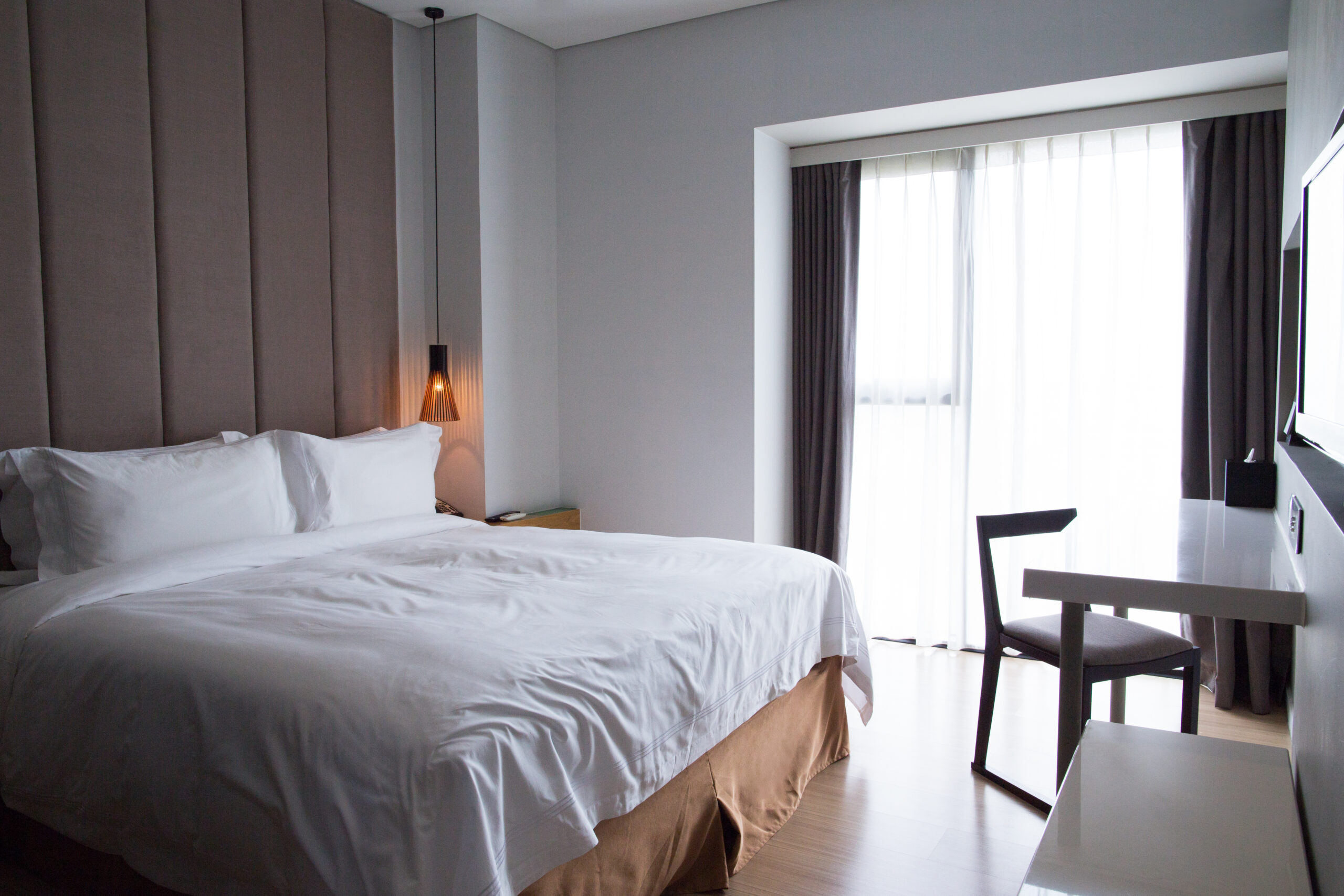 Hotel bedroom with double bed, table and TV set especialistas en mobiliario para hoteles en barcelona - habitacion